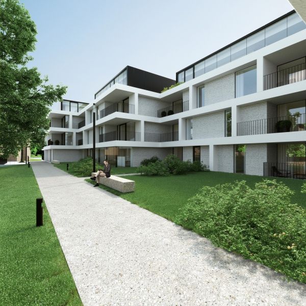 Modern white apartment complex with balconies and garden